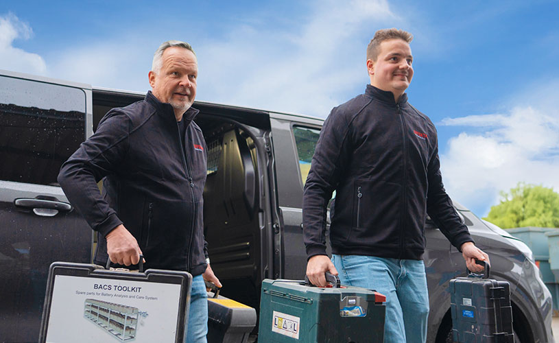 Zwei EFFEKTA-Mitarbeiter holen Werkzeugkoffer und Material aus einem Transporter, um Wartungsarbeiten an einer USV-Anlage durchzuführen.