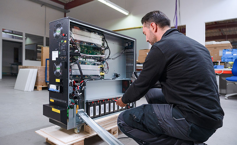 Ein EFFEKTA-Mitarbeiter bearbeitet in der Fertigung eine USV-Anlage, um höchste Qualität und Langlebigkeit sicherzustellen.