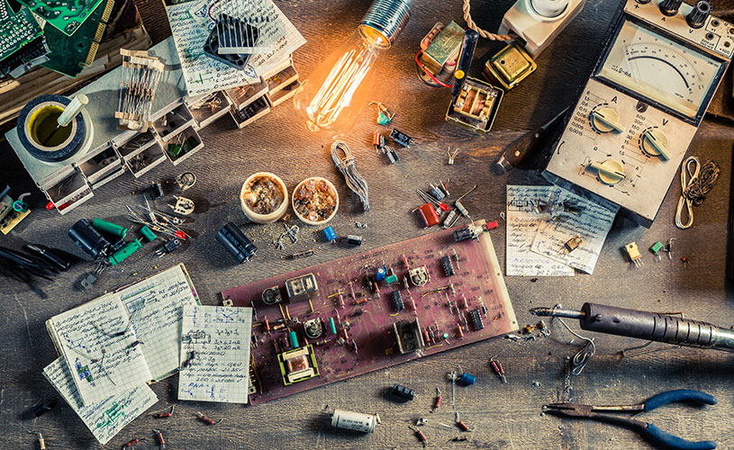 Elektronik-Arbeitstisch mit verschiedenen Komponenten, der die Anfänge von EFFEKTA als Elektronikunternehmen symbolisiert.