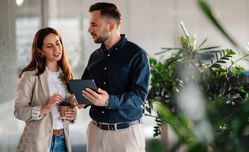 Zwei Business-Team-Führungskräfte, ein Mann und eine Frau mittleren Alters besprechen ein Projekt.